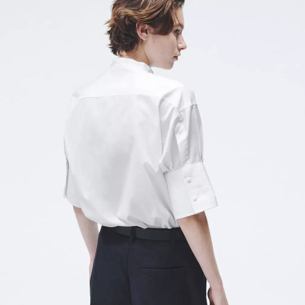 The Ayla. The timeless button down is elevated with a boxy cut and short sleeves. Pintucked along a buttoned front, this collarless style is crafted in our signature cotton poplin and trimmed in silk