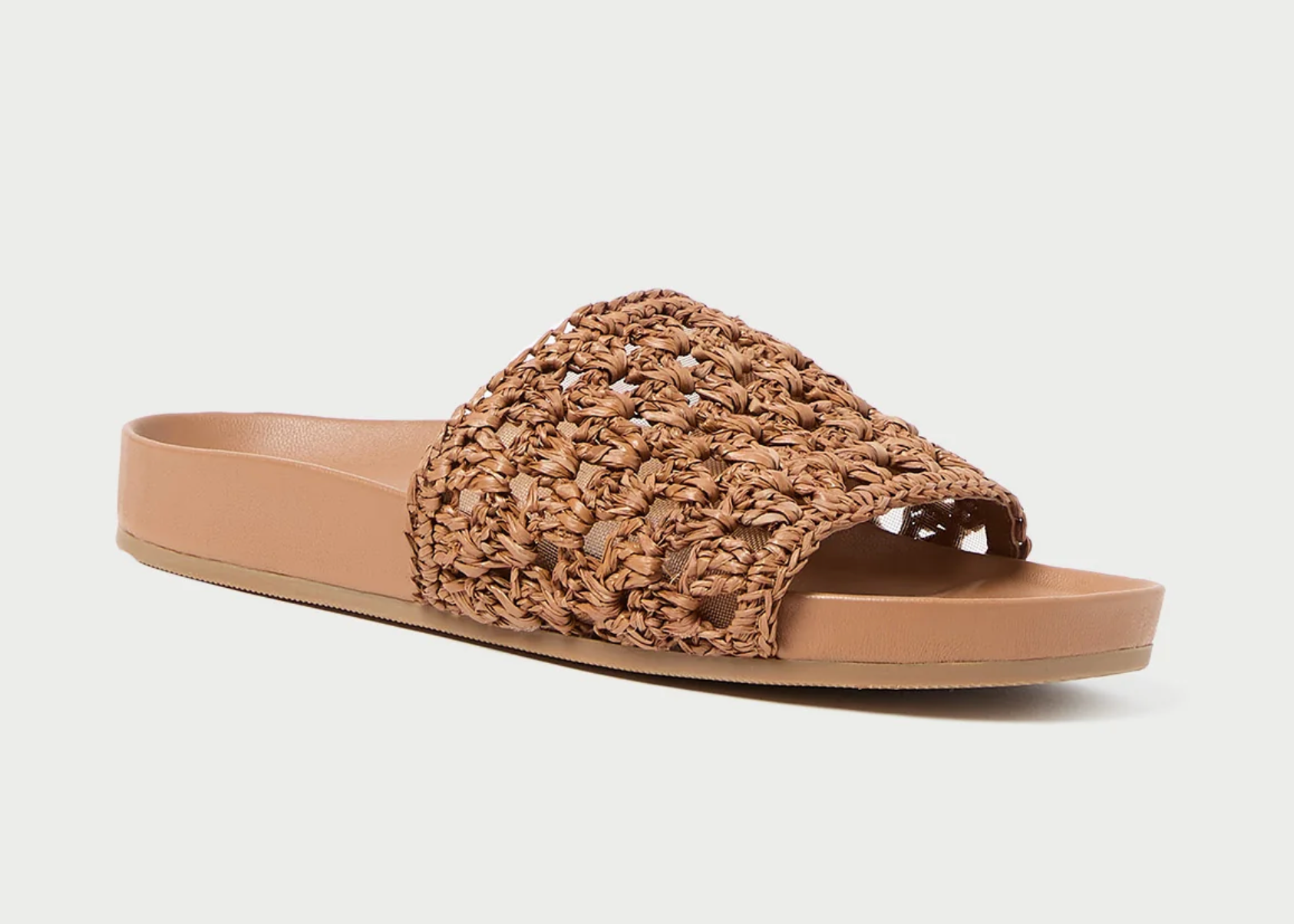 Flat slide sandal in brown crocheted leather. Features a padded leather footbed, a tonal leather sole, and an open toe. Slips on