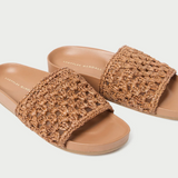 Flat slide sandal in brown crocheted leather. Features a padded leather footbed, a tonal leather sole, and an open toe. Slips on