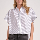 Woman wearing a white and gray striped shirt with short sleeves on a plain background
