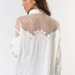 Woman wearing a white blouse with mesh back design on a white background